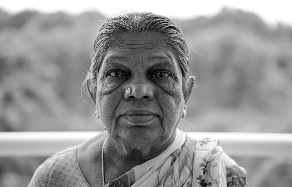 Expressive black and white portrait of an elderly woman outdoors, captured in Bengaluru, India.
