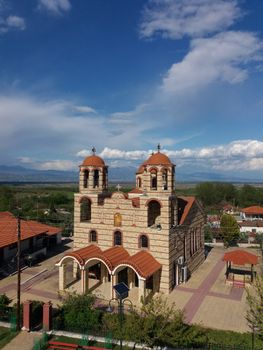 Aerial shot showcasing the architectural beauty of a traditional church under a clear blue sky. — photo by Panagiotis Pistofidis