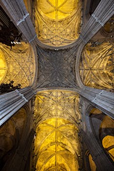 Intricate Gothic ceiling of Seville Cathedral, showcasing architectural details.