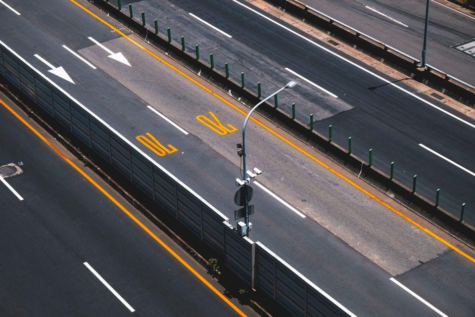 Aerial view of a modern highway with clear lane markings and street lights.