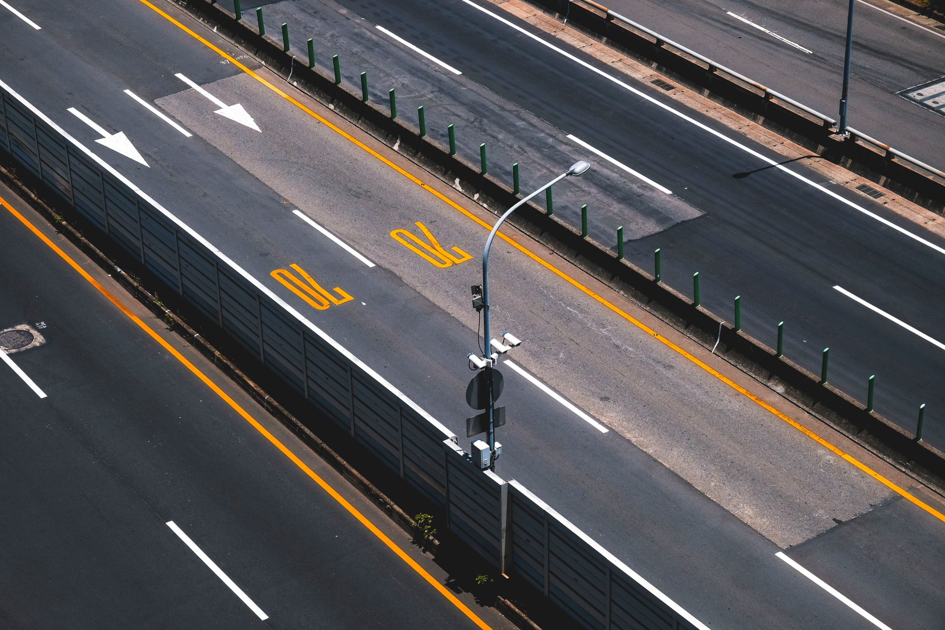 Aerial view of a modern highway with clear lane markings and street lights.