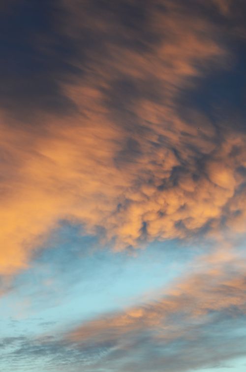 Free Vibrant sunset clouds creating a picturesque view in the evening sky, perfect for backgrounds and themes of tranquility. Stock Photo