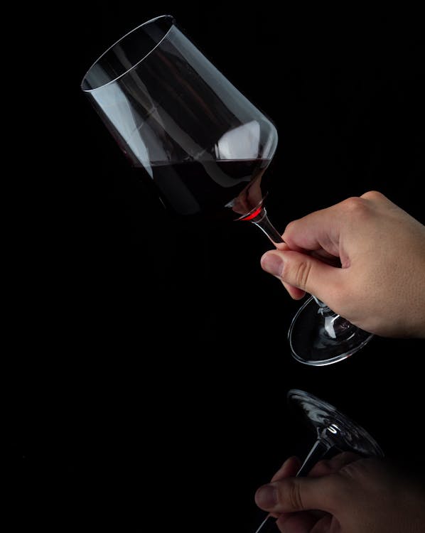 Free Person Holding Clear Wine Glass With Red Wine Stock Photo