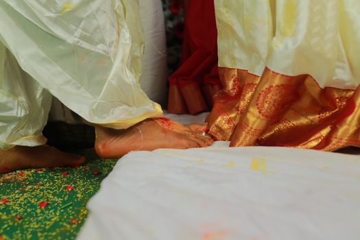 Close-up shot of bride and groom's feet during a traditional wedding ceremony.