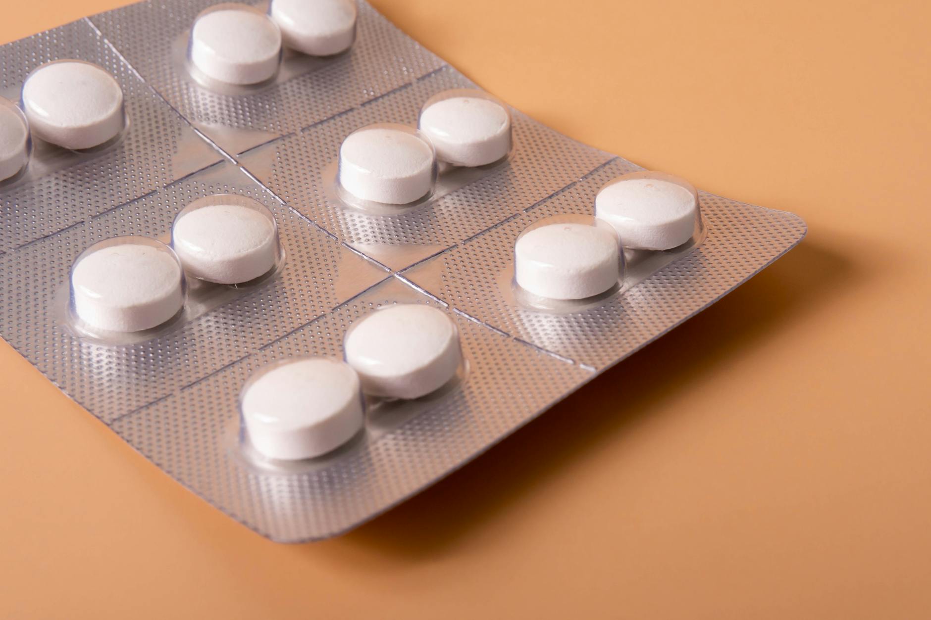 Travel Container Of Pain Relievers On A Table With A Handbag In The Background