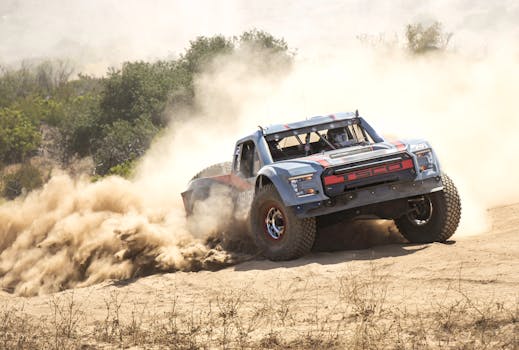 High-speed off-road race truck kicking up dust in the Mexican desert, capturing the thrill of motorsport.