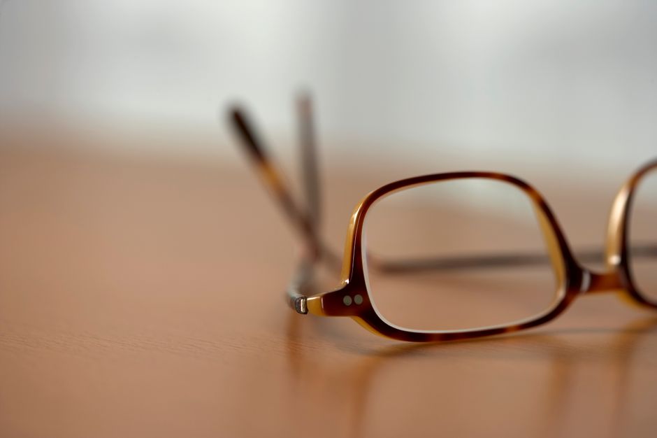 A close-up view of stylish brown eyeglasses resting on a wooden table.