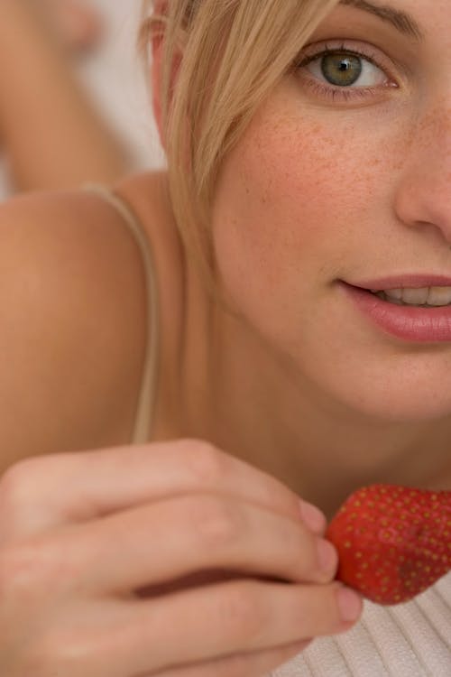 Close Up Photo of Woman Holding a Strawberry