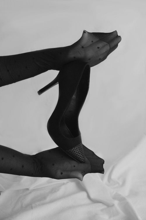 Free Monochrome image of hands holding a black high heel shoe, exuding elegance and fashion. Stock Photo