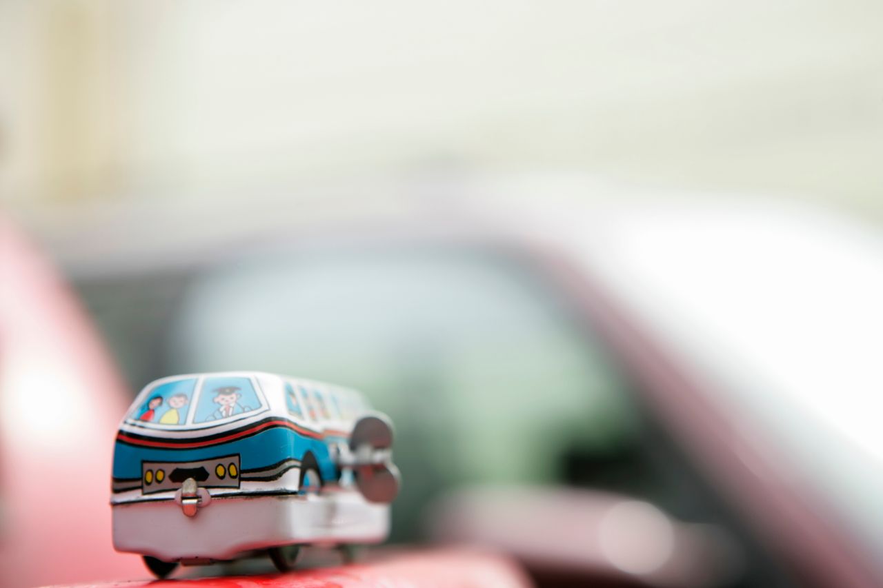 a detailed focus on a wind up toy bus with a blurred background highli