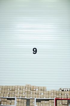 Simple warehouse scene with stacked boxes and a large number 9 on the wall.