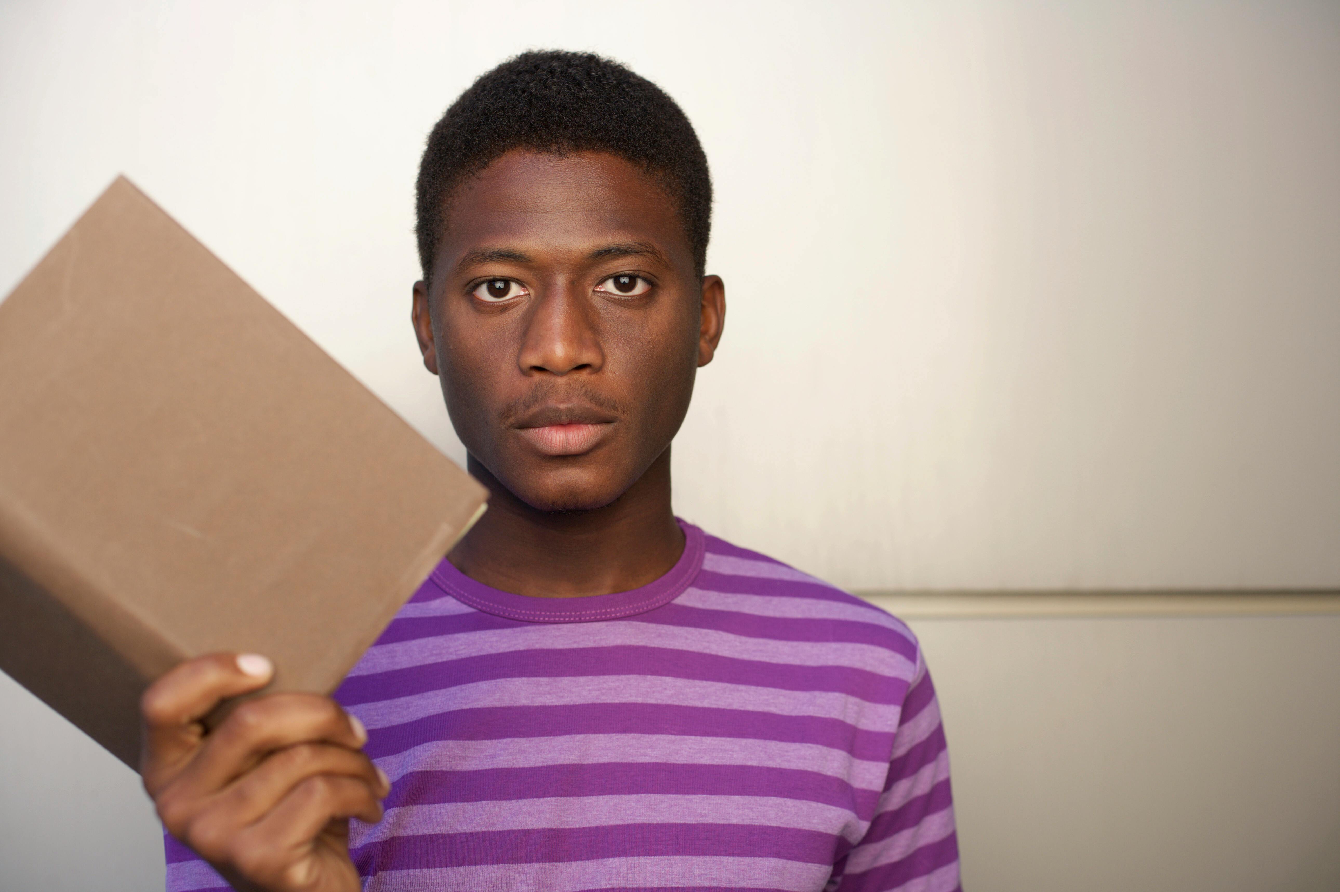 photo of a man holding a brown book