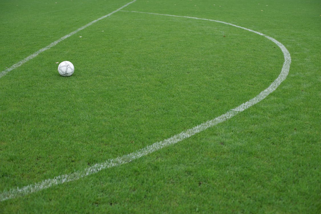 White Soccer Ball on Green Grass Field