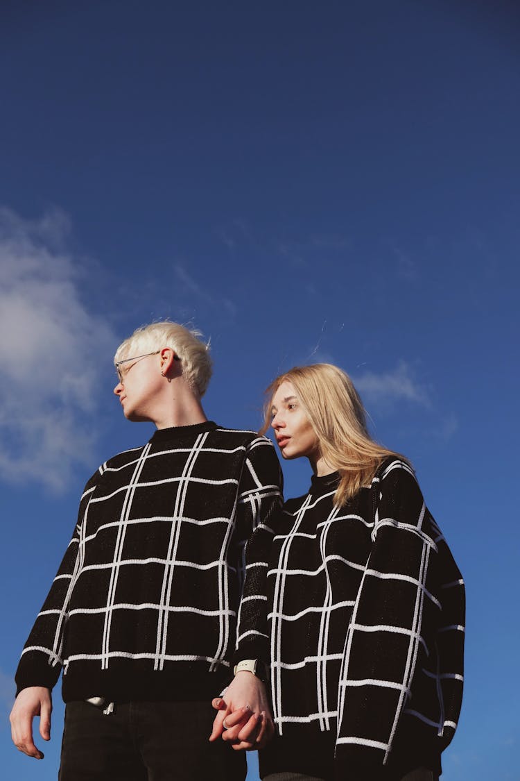 Couple Wearing Matching Blouses Against Blue Sky