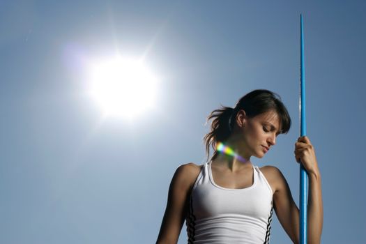 Woman athlete with javelin against a sunny sky, showcasing strength and focus. — photo by BOOM 💥 Photography