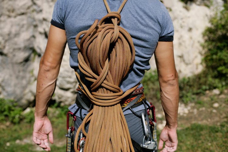 A Mountain Climber With Ropes On His Back