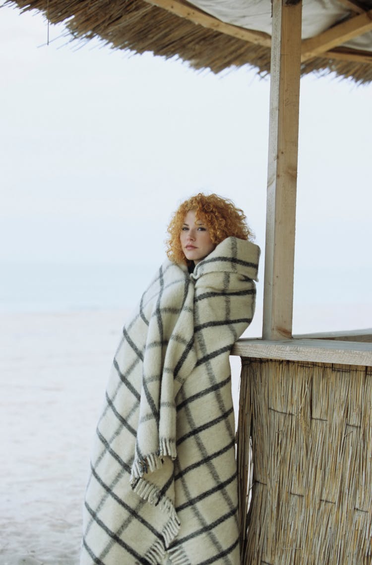 Woman Covered With Blanket On Beach