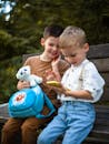 Two Boys Sitting on Wooden Bench