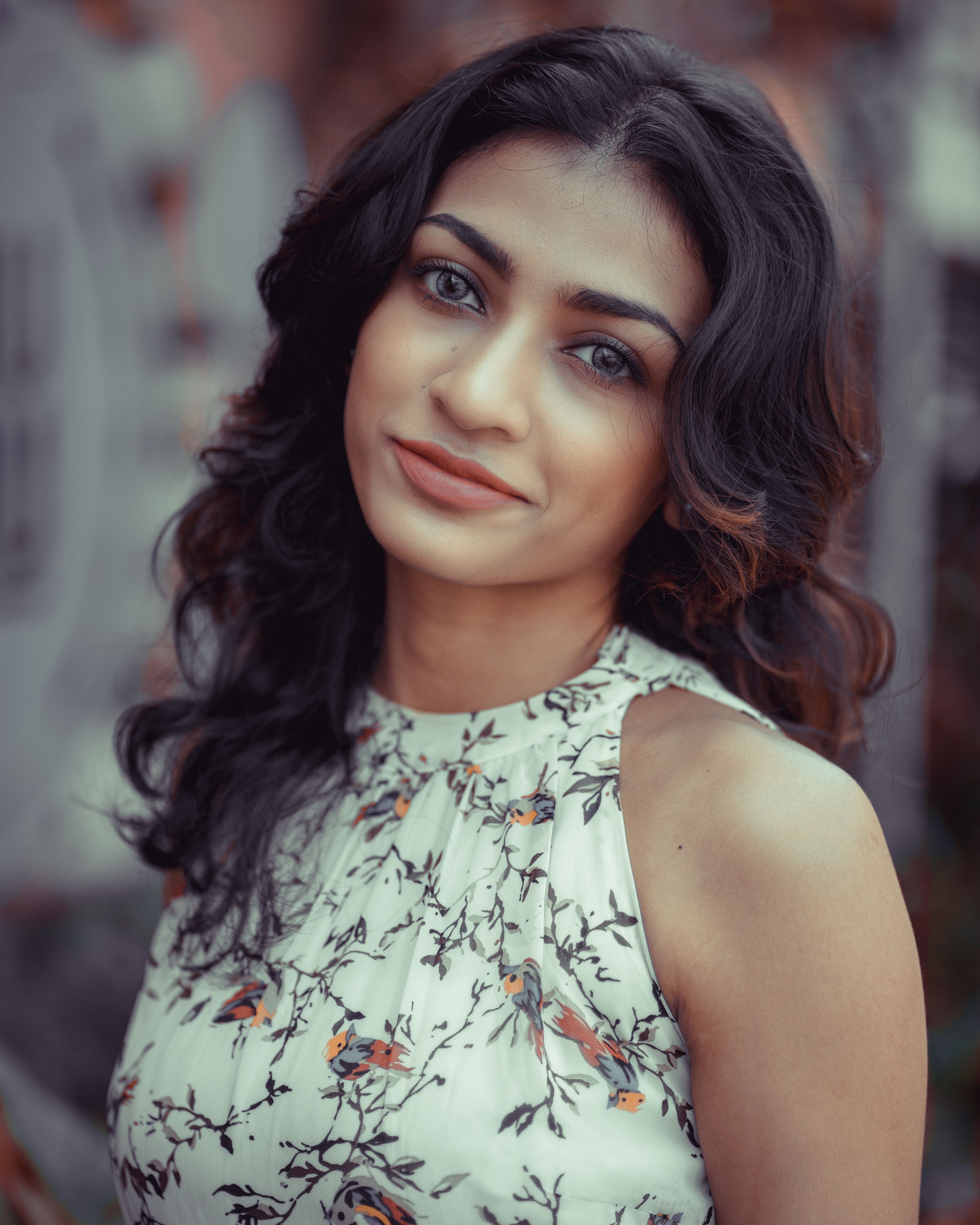 A close-up portrait of a smiling woman outdoors, embodying natural beauty and elegance.