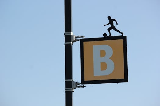 Outdoor sign depicting a soccer player silhouette on letter B background.