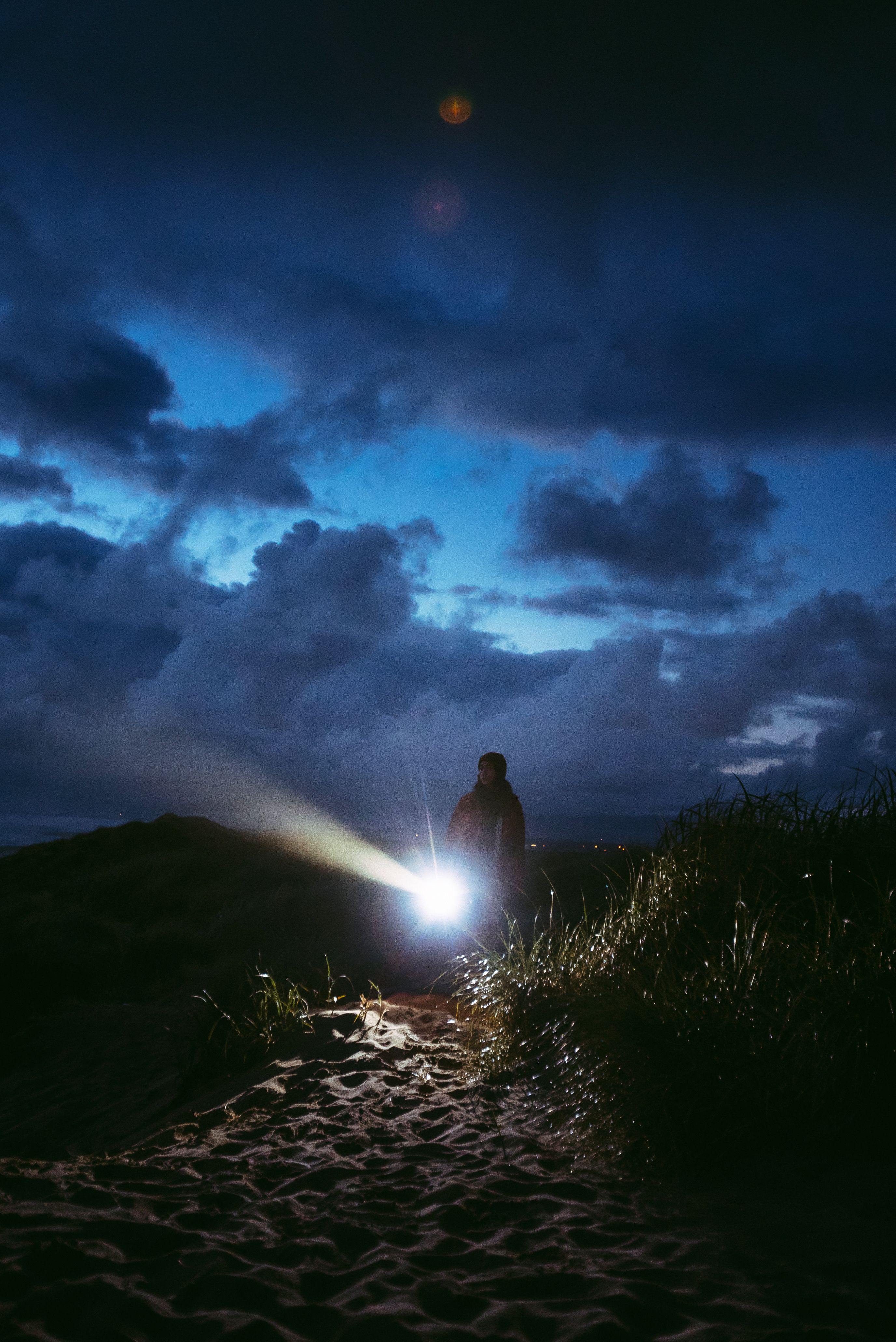 Traileur éclairant un sentier de nuit avec sa lampe frontale