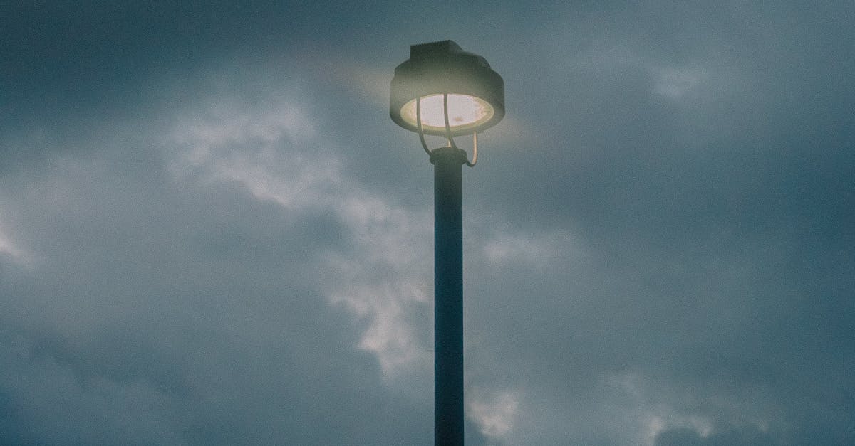 Photo by Juan Gomez A street light illuminates under stormy clouds during dusk in Hawaii, USA.
