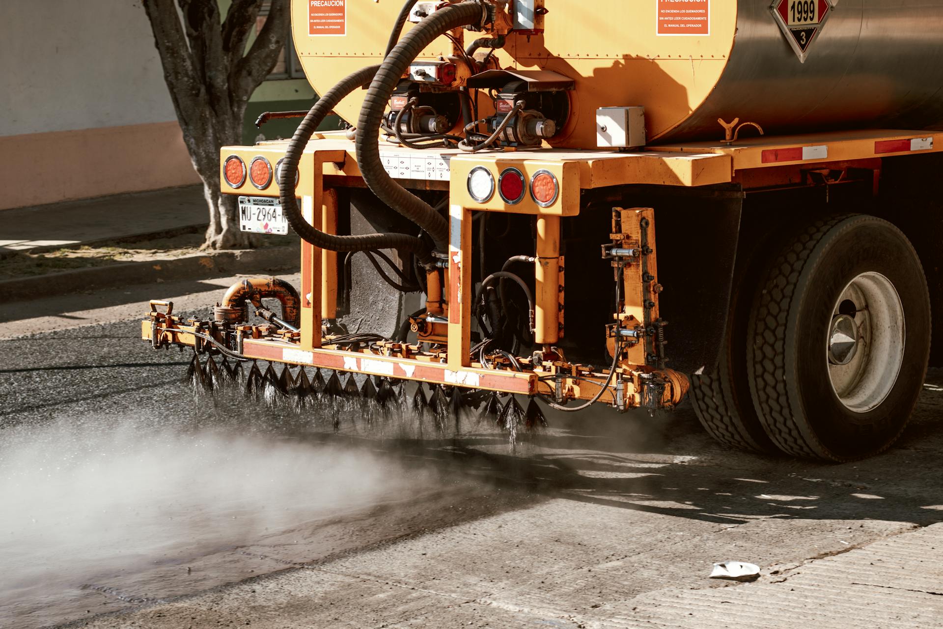 Close-up of a truck performing road maintenance with spray equipment in Mexico.