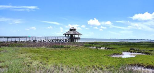 Free Tranquil scene of a wooden gazebo and dock extending into the waters under a blue sky in Port Lavaca, Texas. Stock Photo