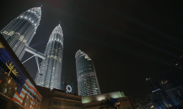 A stunning nighttime view of the Petronas Twin Towers illuminated in Kuala Lumpur, Malaysia.