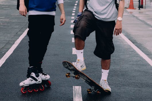 Two individuals enjoy skateboarding and rollerblading on an empty road, showcasing urban recreation.