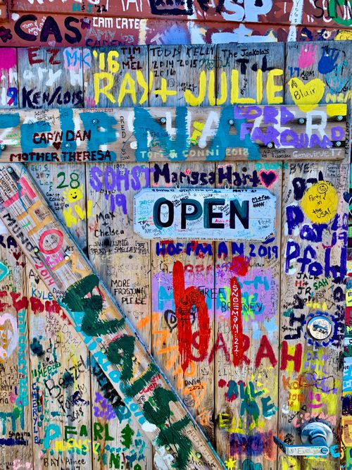 Free Vibrant graffiti art on a wooden door in Ephraim, WI, showcasing colorful signatures and creative expressions. Stock Photo