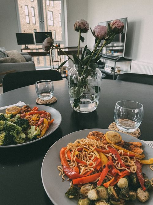 Free Inviting indoor dining setup featuring fresh flowers, healthy food, and cozy atmosphere. Stock Photo