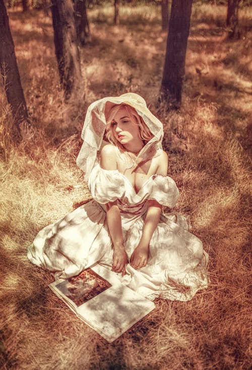 Woman in White Dress Sitting on Brown Grass