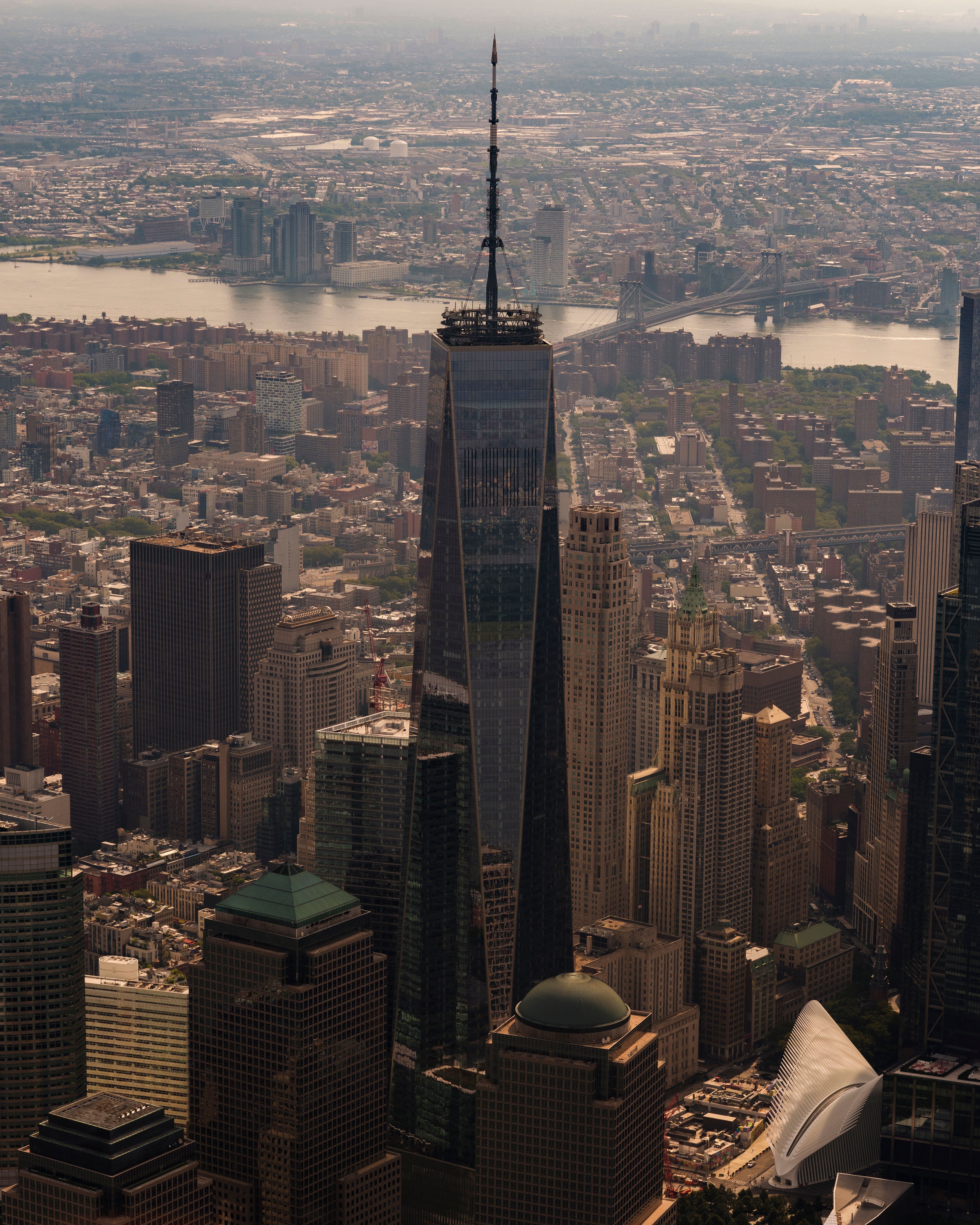 Stunning aerial view of One World Trade Center towering over New York City skyline with Hudson River