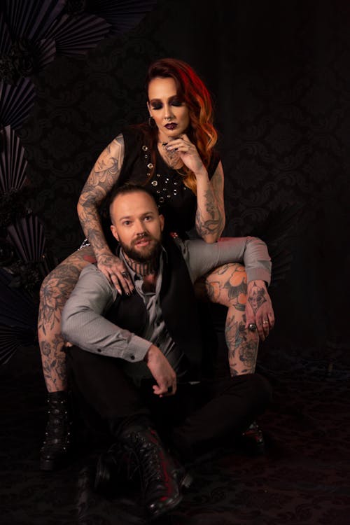 Tattooed Couple Posing for Photo on Black Background 