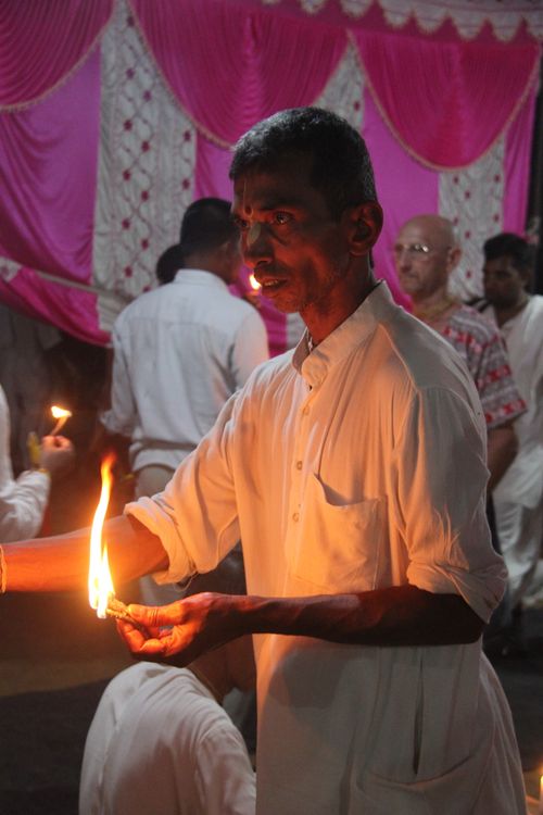 Free A man participates in a traditional candle ceremony indoors at Vrindavan, India. Stock Photo