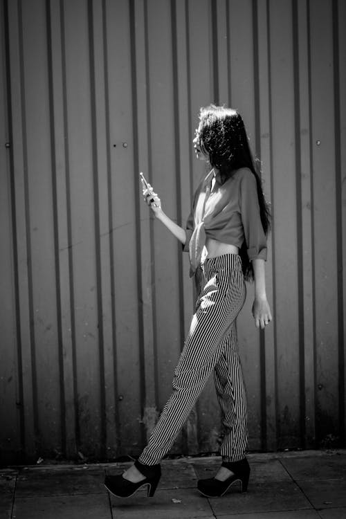 Grayscale Photo of a Woman Walking