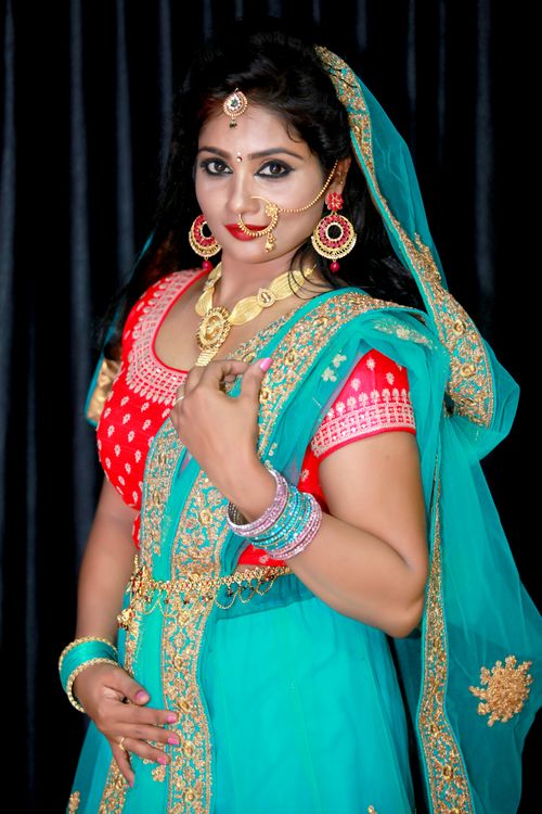 Free A beautiful Indian bride in a turquoise and red sari adorned with traditional jewelry. Stock Photo