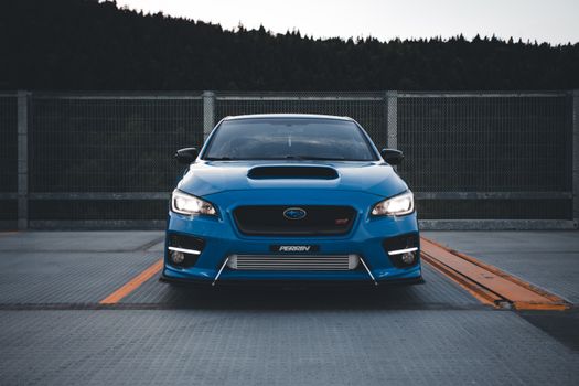 A striking blue Subaru sports car parked outdoors, showcasing its sleek design and performance-oriented features.