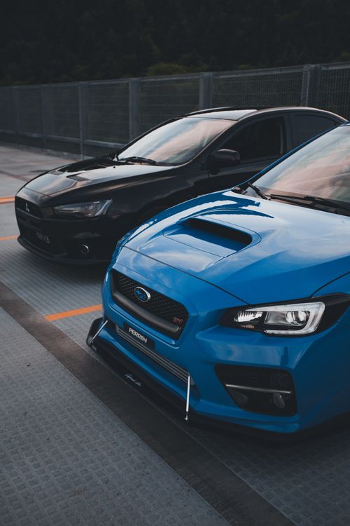 Free Two sleek sports cars parked in an outdoor lot, showcasing automotive design. Stock Photo