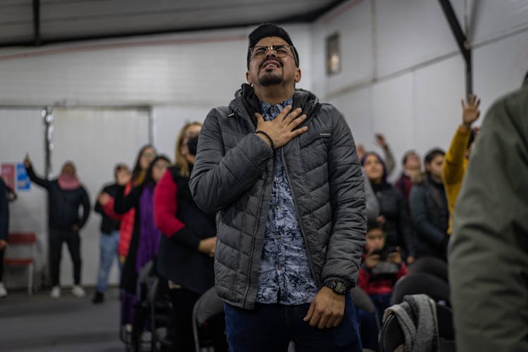 Man Standing In A Line And Clutching His Throat 