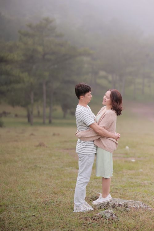 Free A loving couple embraces in a foggy meadow in Vietnam, capturing intimacy and romance. Stock Photo