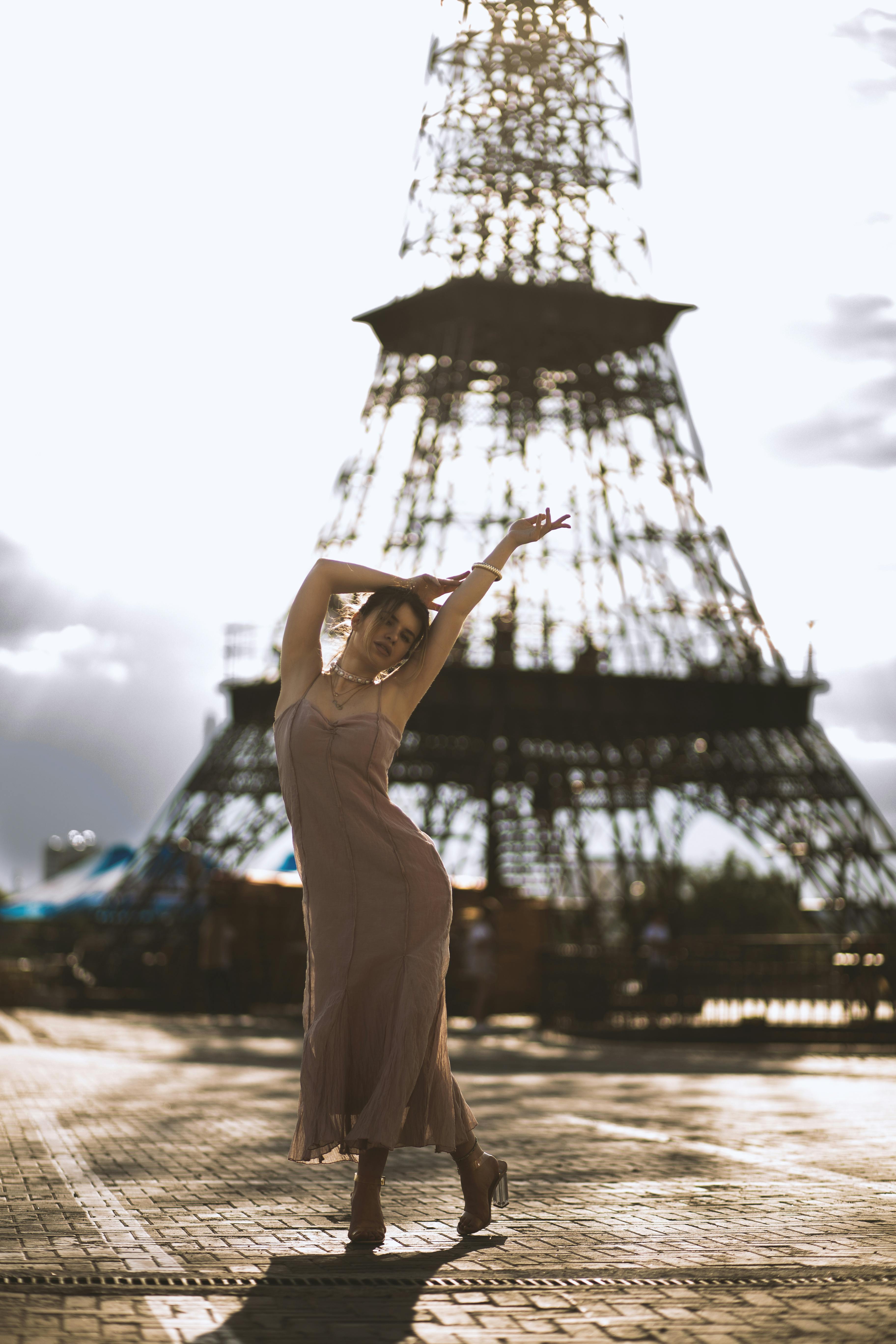 日落时分，一位时尚女性在埃菲尔铁塔前优雅地摆着姿势