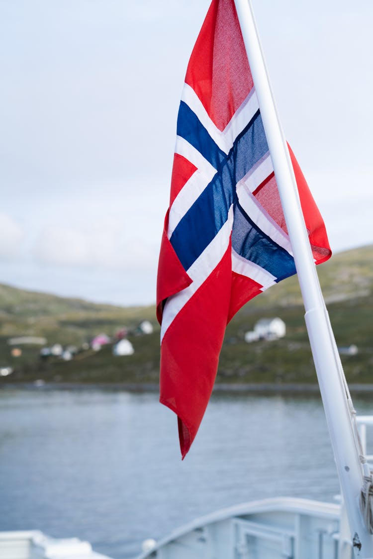 Norwegian Flag With Mountains And Lake In The Background 