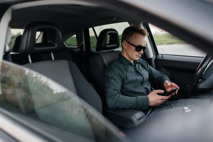 Man Sitting In A Car And Using Phone 