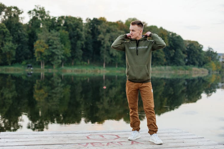 Man In Casual Clothing Standing On Pier Near Water