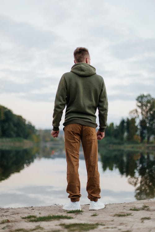 Man Standing on Lake Shore and Looking At View 