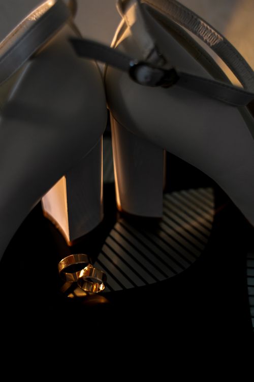 Free A close-up shot of sophisticated high heels paired with golden rings, perfect for wedding themes. Stock Photo