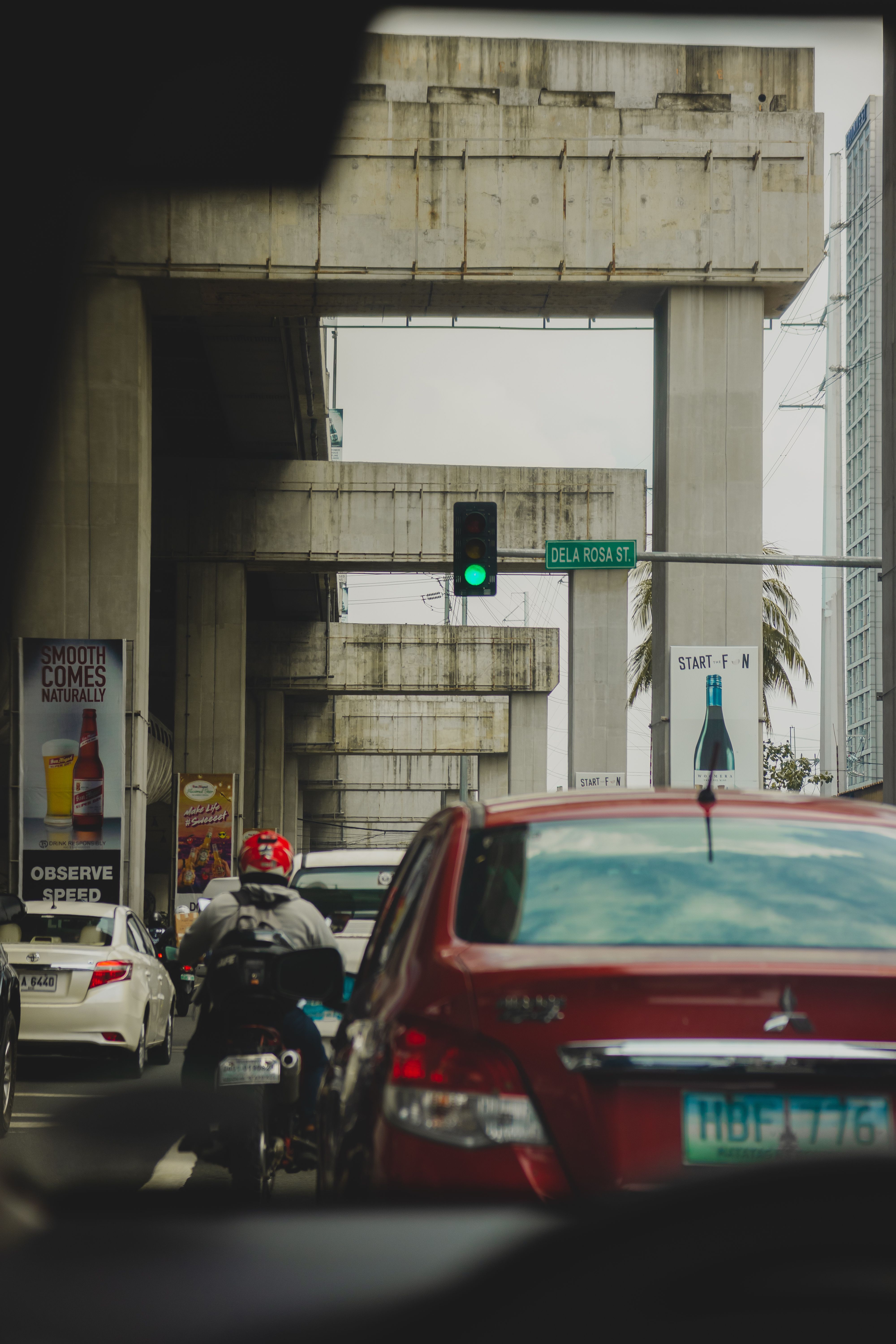 Dynamic urban traffic scene featuring cars and motorcycles on a city street beneath concrete structures.