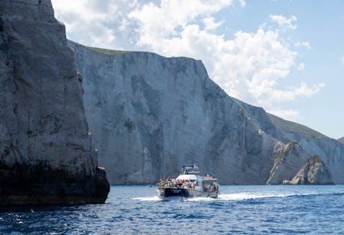 People on Motor Yacht near Cliff